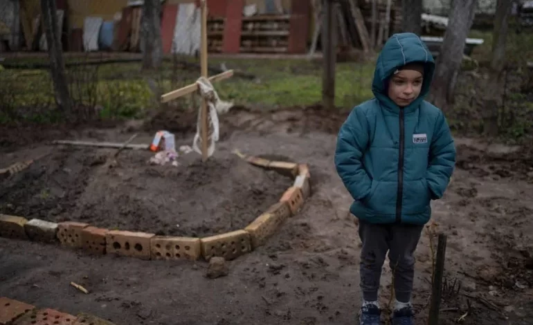 آثار العدوان الروسي على أوكرانيا...مشهد مؤثر لطفل أوكراني يبكي بجوار قبر أمه